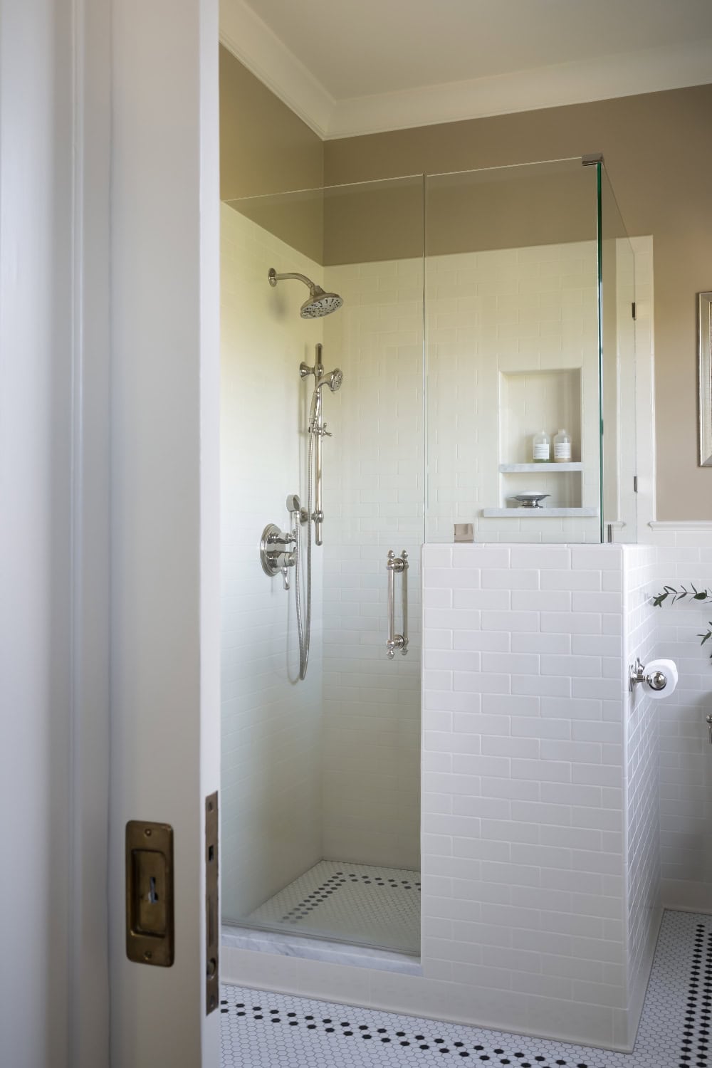 Warm neutral bathroom with period appropriate fixtures including plumbing, lighting, tile, cabinetry, and wainscot.